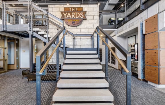 a staircase in a building with a large sign on the wall that says the yards