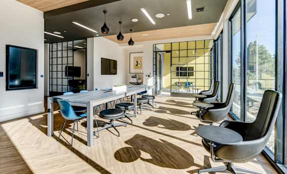 a conference room with a long table and chairs and large windows