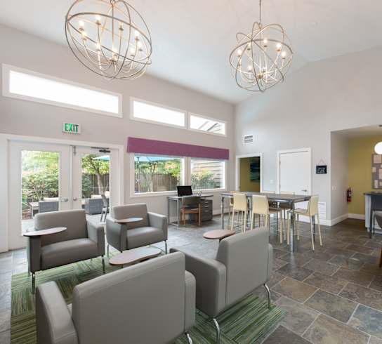 A spacious room with a dining table surrounded by chairs.