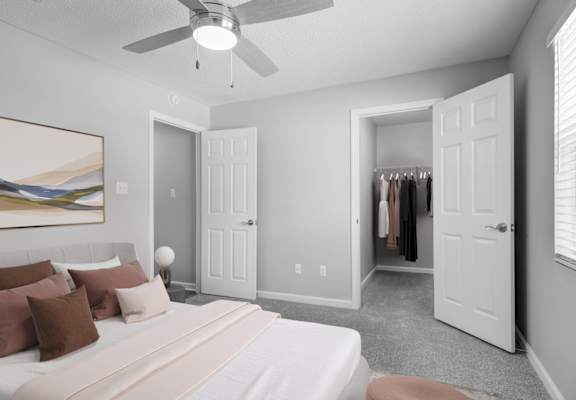 a bedroom with a white bed and a ceiling fan