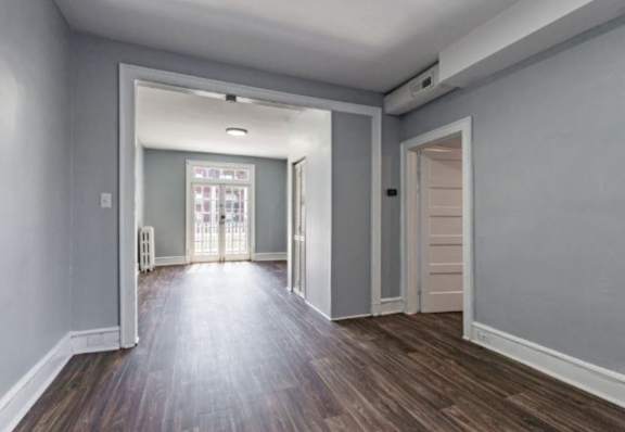 A room with a wooden floor and white walls.