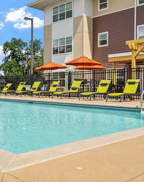 A large apartment building with a parking lot in front.