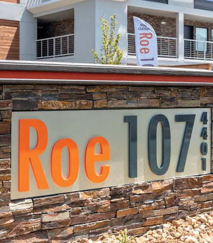 A sign that says Roe 107 is on a stone wall.