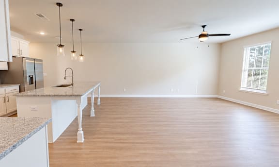 A kitchen with white cabinets and a marble countertop.