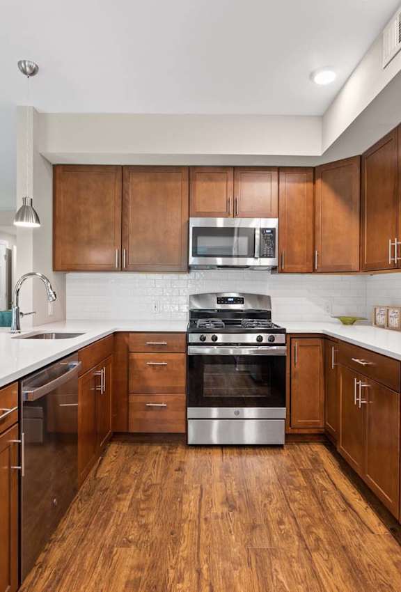 A modern kitchen with wooden cabinets and stainless steel appliances.