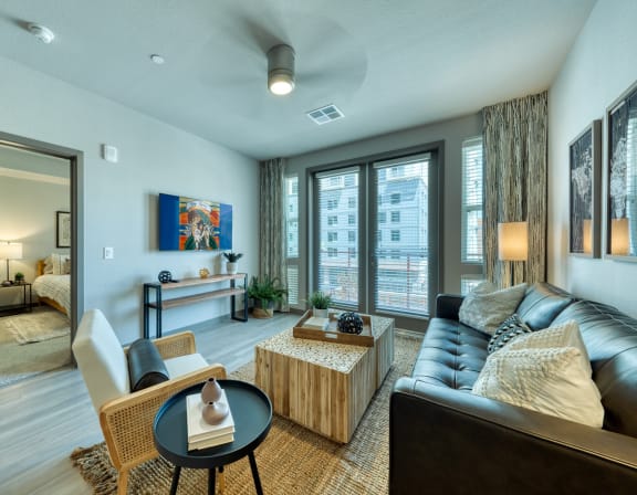 a living room with a couch coffee table and large windows at The Rey Downtown, Phoenix, 85003