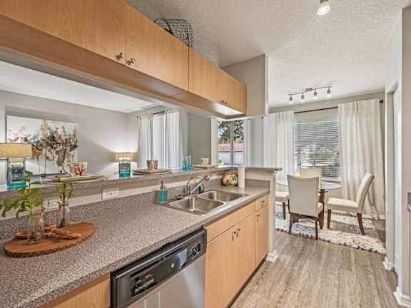 A kitchen with a granite countertop and stainless steel appliances at Heritage Bay, Jensen Beach, 34957