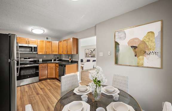 A modern kitchen with a dining table set for four.