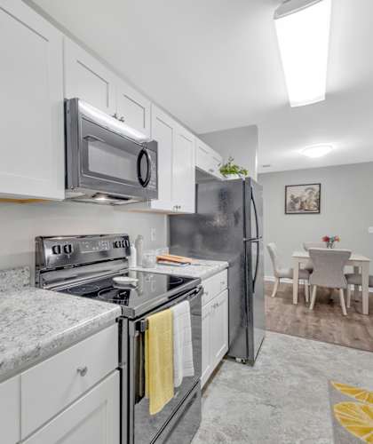 A kitchen with white cabinets and a granite countertop.