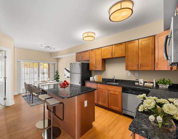 A kitchen with wooden cabinets and a black countertop.