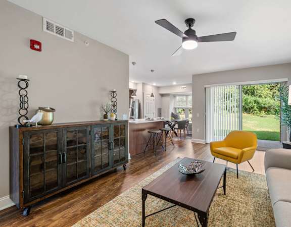 A living room with a yellow chair and a brown coffee table.