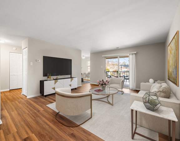 A living room with a white couch, a coffee table, and a television.
