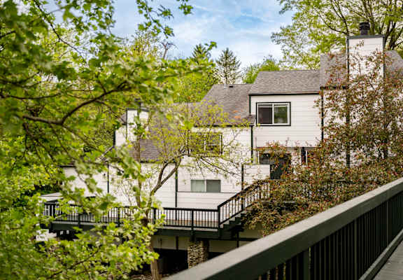 A white house with a black railing and a balcony.