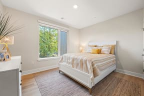 a bedroom with a bed and a large window