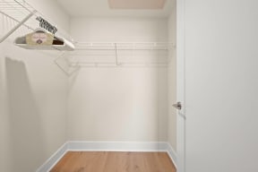 a walk in closet with white walls and a white closet door