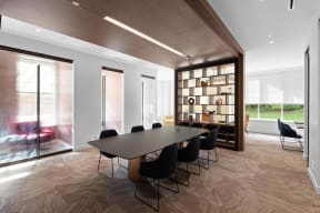 a conference room with a table and chairs and a bookshelf