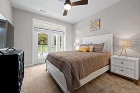 a bedroom with a bed and a door to a patio
