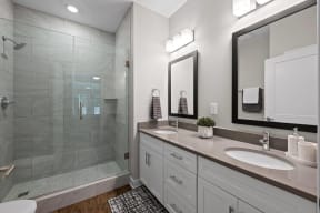 a bathroom with two sinks and a glass shower
