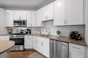 a white kitchen with stainless steel appliances and white cabinets