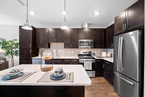 a large kitchen with stainless steel appliances and white counter tops