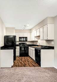 a kitchen with wooden cabinets and stainless steel appliances at The Beacon, Alabama