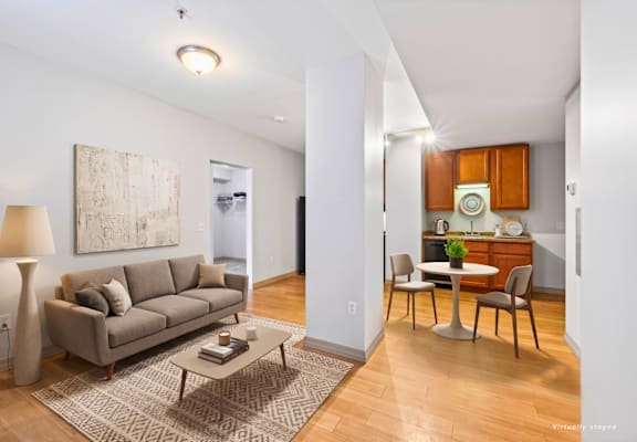 A living room with a grey couch, a coffee table, and a painting on the wall.