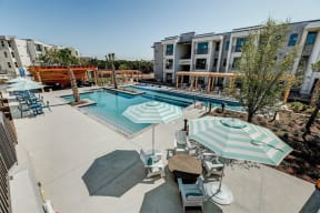 apartments with a pool and patio with umbrellas