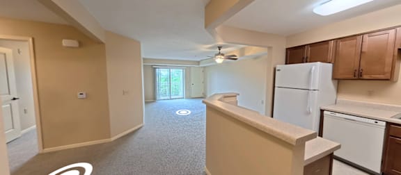 A kitchen with a white refrigerator and brown cabinets.