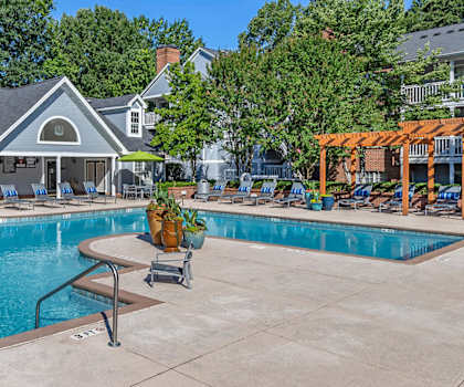 A pool with a house in the background.
