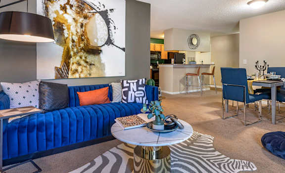 A living room with a blue couch and a coffee table.