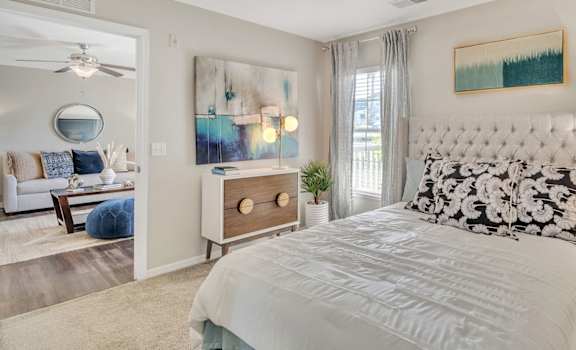 A bedroom with a large bed and a painting on the wall.