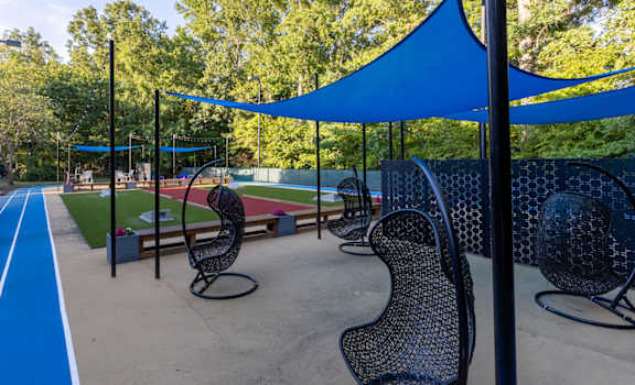 A blue track and chairs under a blue canopy.