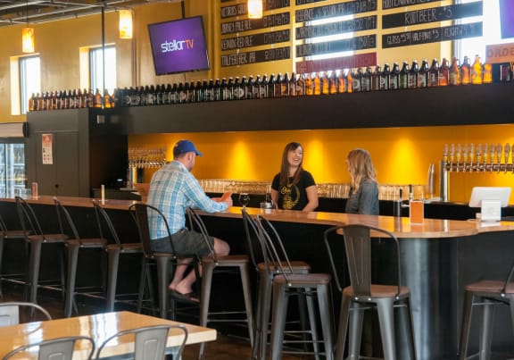 a man and two women sit at a bar in a restaurant