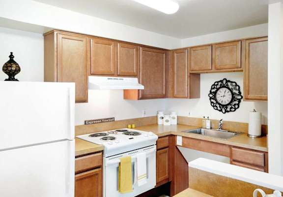 A kitchen with wooden cabinets and a white refrigerator.