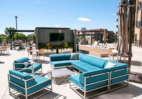 a seating area with blue couches and chairs on a patio