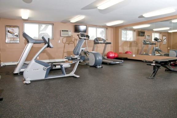 Bass Lake Crossing Fitness Center With Floor To Ceiling Mirrors on Full Wall and Aerobic Equipment
