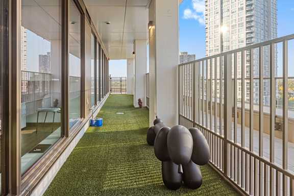 A balcony with a green lawn and a person standing on it.