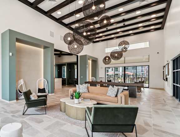 A modern living room with a green chair and a brown couch at Ironwood Ranch Apartments,Maricopa,AZ.