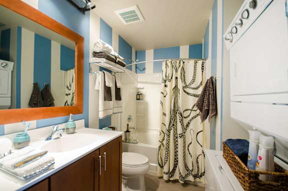 A bathroom with blue and white striped walls.