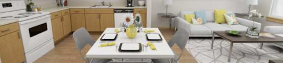 A modern kitchen with a dining table set for two.