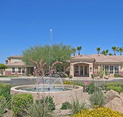 a fountain in front of a house with a circular fountain