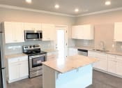 Thumbnail 27 of 60 - B3 (1-car) Kitchen with island, granite countertops, stainless steel appliances