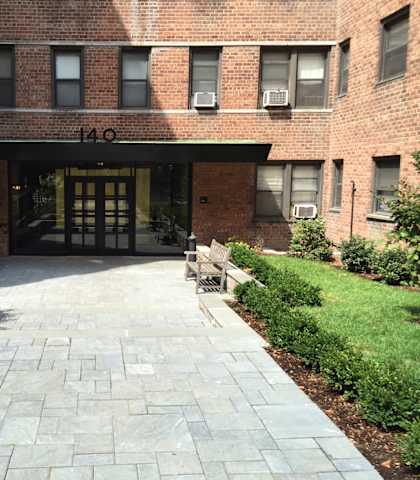 a brick building with a stone walkway in front of it