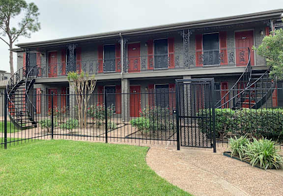 a building with red doors and a fence in front of it
