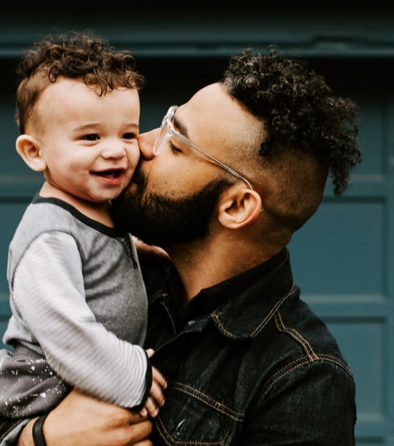 Father Holding Son and Kissing Him on Cheek