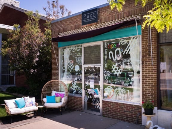 the front of a cafe with furniture outside of it