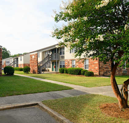 an exterior view of an apartment building with sidewalks and grass