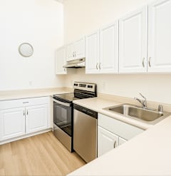 A kitchen with white cabinets and a black dishwasher.