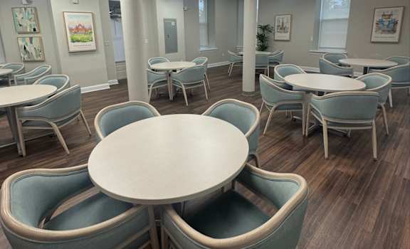 A room with tables and chairs and a skylight.