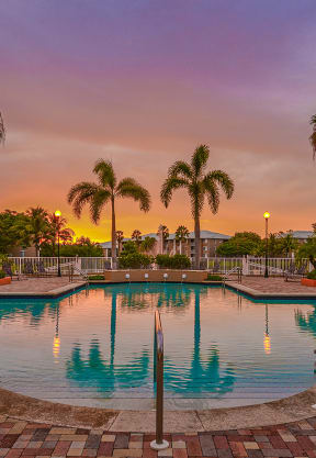 a large swimming pool with palm trees at sunset at Promenade at Reflection Lakes, Fort Myers, FL